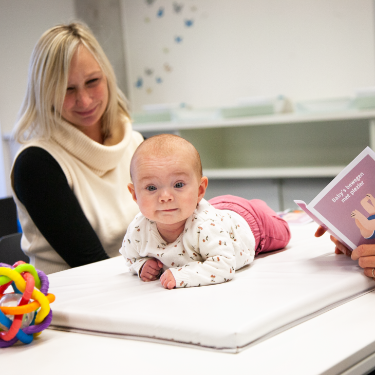 baby in buiklig met mama en verpleegkundige op het consultatiebureau