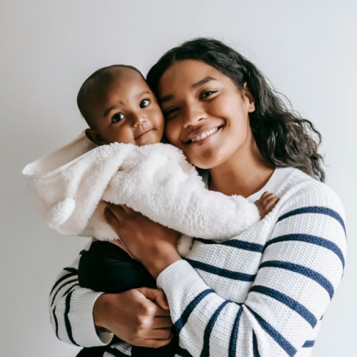 Mama houdt baby in haar armen en glimlacht