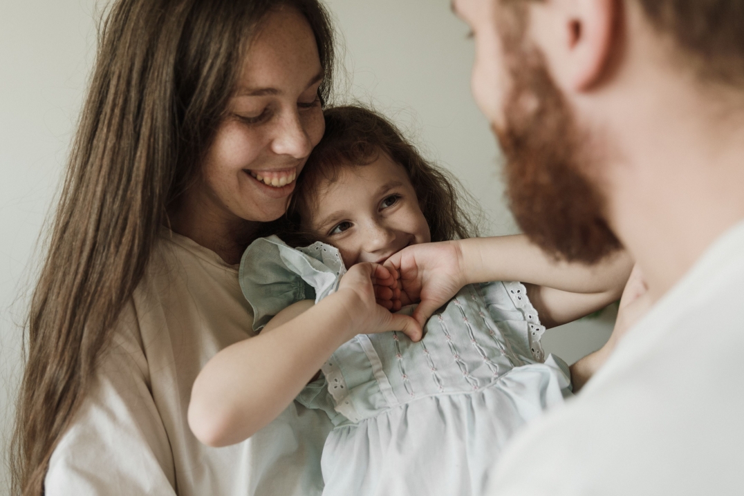 Ouders en kind delen een warm en liefdevol moment samen thuis.