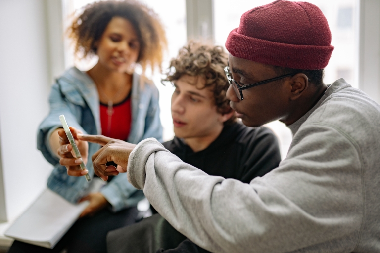 Jongeren kijken samen op smartphone.